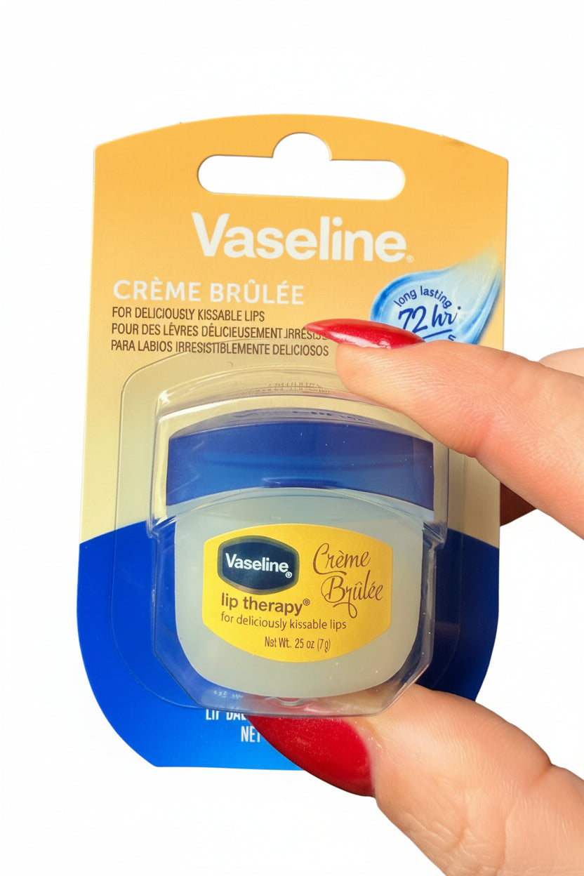 Vaseline lip balm packaging with a hand holding it against a dark background