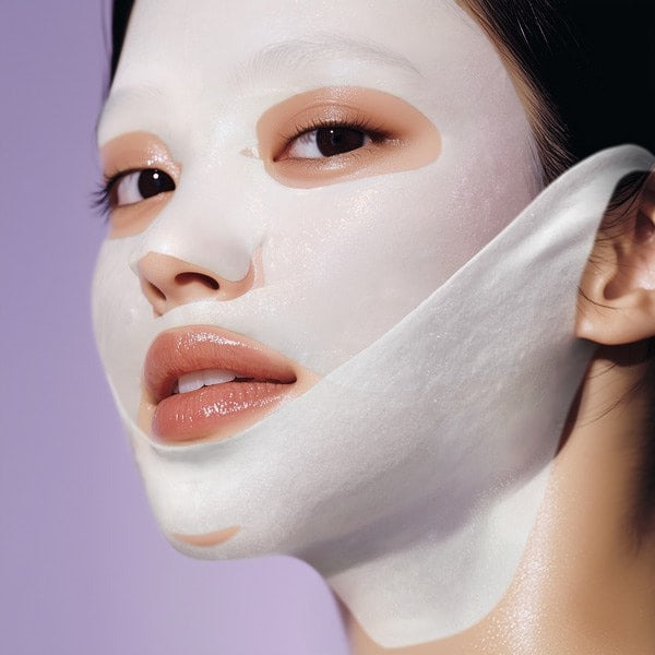 Person applying a white face mask with a purple background